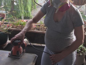 Schwangere Frau renoviert mit Atemschutzmaske