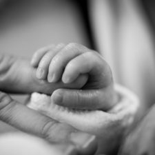 Babyhände umfassen die Finger der Mutter
