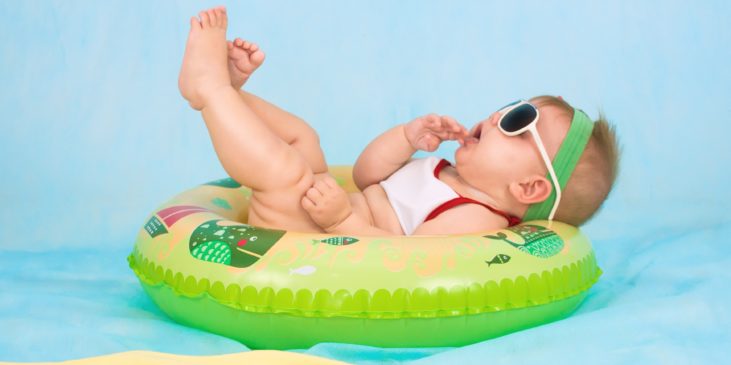 Baby chillt mit Sonnenbrille im Schwimmreifen