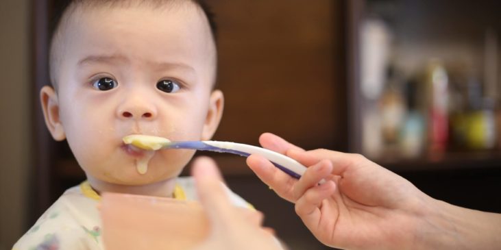 Baby wird mit Brei gefüttert