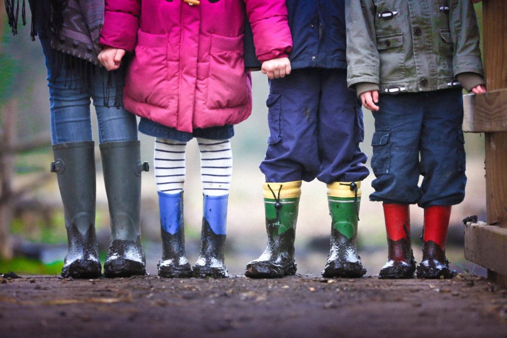 Kinder Beine in Gummistiefel. Vielleicht hat eines von vier Kindern FAS FASD weil die Mutter in der Schwangerschaft Alkohol konsumiert hatte?