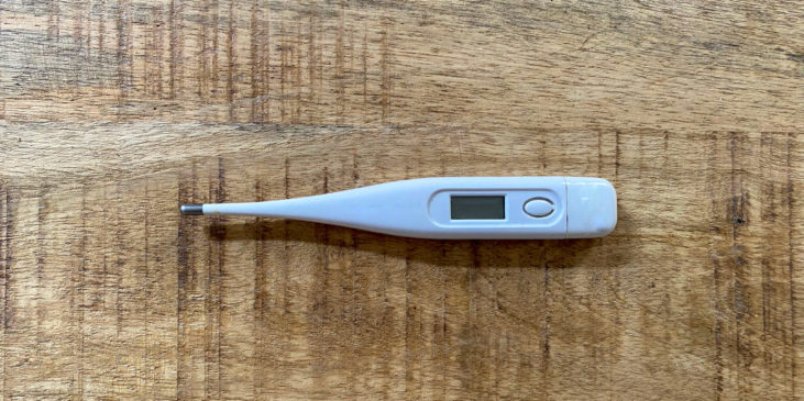 Ein starkes Fieberthermometer auf einen Holz Tisch von einer kranken, alleinerziehenden Mutter